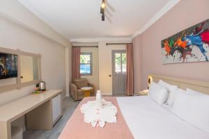 a bedroom with a white bed and a tv at Casa De Levıssı Ölüdeniz in Oludeniz