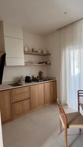 a kitchen with wooden cabinets and a chair and a window at MIRA MARE - Apartment 5 in Stavros
