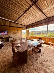 a large dining room with a table and chairs at Pousada Flat Royal Suíte com varanda e rede in Itapecerica