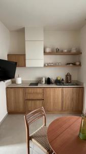 a kitchen with wooden cabinets and a table and a chair at MIRA MARE - Apartment 5 in Stavros