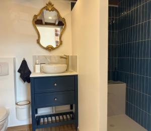 a bathroom with a blue sink and a mirror at Le Cantilien Apartment - Chantilly in Chantilly