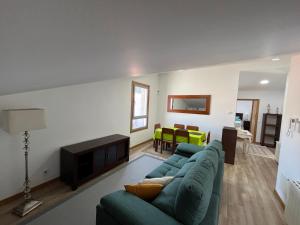 a living room with a green couch and a fireplace at Ático en pleno centro en Cangas in Cangas de Morrazo