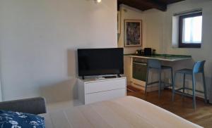 a living room with a television and a desk with a table at Terrazza Tosti in Formia