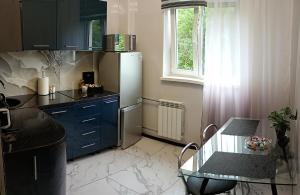 eine Küche mit einem Glastisch und einem Kühlschrank in der Unterkunft Michael Apartment in Valga