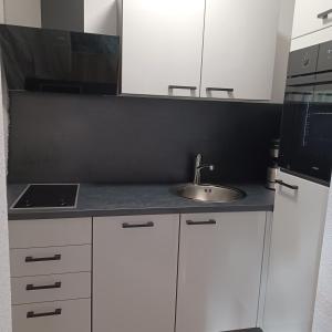 a kitchen with white cabinets and a sink at Heideglück in Visselhövede