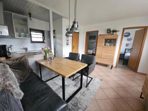 a living room with a table and a couch at Boddenhaus Stahlbrode in Reinberg +11 photos