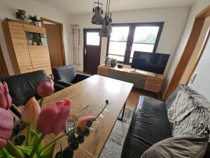 a living room with a couch and a table with flowers at Boddenhaus Stahlbrode in Reinberg