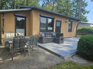 a patio with a couch and a table and chairs at Boddenhaus Stahlbrode in Reinberg