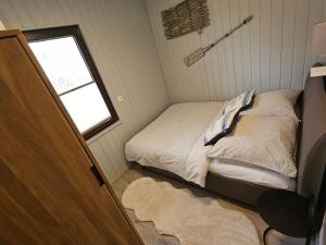 a small bedroom with a bed and a window at Boddenhaus Stahlbrode in Reinberg