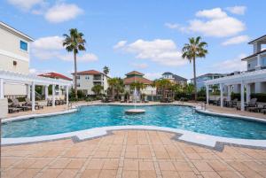 a swimming pool at a resort with palm trees at Gulf View Beach Home with Pool in Gulf Shores