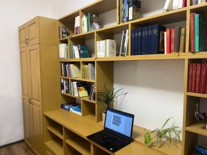 a laptop computer sitting on a desk in a book shelf at Bookworm Ultracentral Cozy, ultracentral apartment for people who appreciate comfort, details and books in Târgu-Mureş