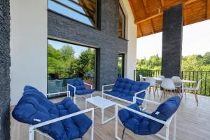 a living room with blue chairs and a table and a patio at Prime - Event & Relax Resort in Jaszczurowa