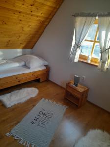 a bedroom with a bed and a window and a rug at Chata pod Urbanovym Vrchom in Čierny Blh