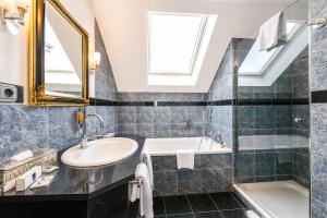 ein Badezimmer mit Waschbecken und Badewanne in der Unterkunft Hotel Rivoli Charme in München + 31 Fotos