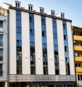 ein Wohnhaus mit weißer Fassade in der Unterkunft Hotel Rivoli Charme in München