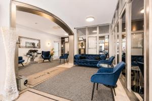 ein Wohnzimmer mit blauen Möbeln und einem Spiegel in der Unterkunft Hotel Rivoli Charme in München