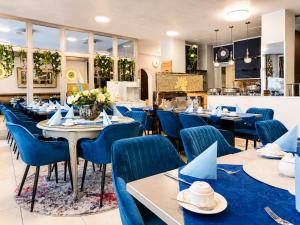 ein Restaurant mit blauen Stühlen und Tischen und einer Theke in der Unterkunft Hotel Rivoli Charme in München