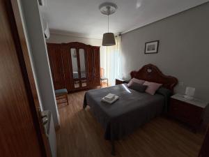a bedroom with a bed with a wooden head board at La casita de Isa in Ciudad-Rodrigo