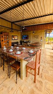 a large dining room with a large table and chairs at Pousada Flat Royal Suíte com varanda e rede in Itapecerica