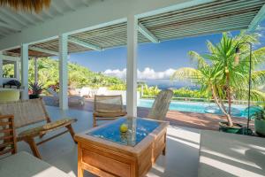 a living room with a view of a pool at Villa Bananes Rouges in Boyer