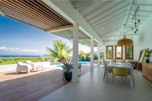 a kitchen and dining room with a view of the ocean at Villa Bananes Rouges in Boyer
