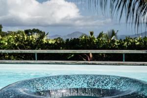 a swimming pool with a bowl in the middle of it at Villa Bananes Rouges in Boyer