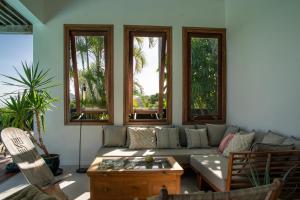 a living room with a couch and windows at Villa Bananes Rouges in Boyer +32 photos