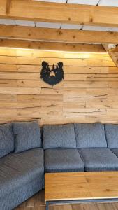 a living room with a blue couch against a wooden wall at Cabana LoSt Ventoc in Vulcan