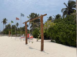 a row of volleyballs courts on a beach with flags at PP Beach Villa in Agatti
