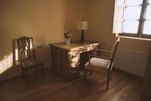 a desk with two chairs and a lamp and a vase with flowers at Casa Pousadoira in Miño +41 photos