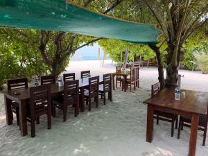 a group of tables and chairs under a tent on the beach at PP Beach Villa in Agatti