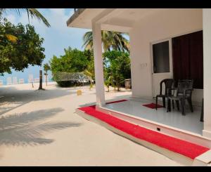 a house on the beach with a red rug at PP Beach Villa in Agatti