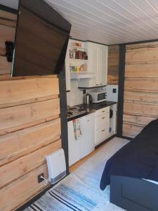 eine kleine Küche mit Bett und Herd in einem Zimmer in der Unterkunft Forest lodge in Lohja