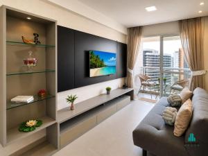 a living room with a couch and a tv at My Way by Holiday Stays in Fortaleza