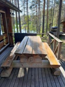 ein hölzerner Picknicktisch auf einer Terrasse im Wald in der Unterkunft Forest lodge in Lohja