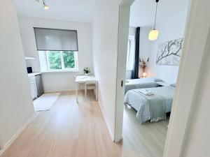 a white bedroom with a bed and a table at Endla Hostel ja Apartamendid in Haapsalu +30 photos