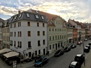 una strada cittadina con auto parcheggiate accanto agli edifici di Central Studio Marktplatz View a Weimar