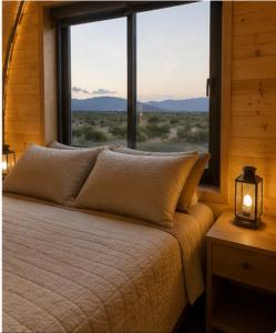 a bed in a room with a large window at Sauron Adventure Bungaloft in Villa Carlos Paz +55 photos
