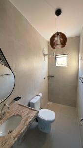 a bathroom with a toilet and a sink and a mirror at Pousada Recanto dos Passaros in Aracati +24 photos