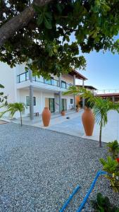 a building with orange vases in front of it at Pousada Recanto dos Passaros in Aracati