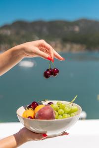 a person is holding a bowl of fruit at Nama Suites in Skopelos Town +29 photos