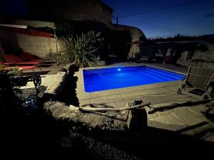 a blue swimming pool in a yard at night at LA MAISON JEROBOAM in Saint-Estèphe