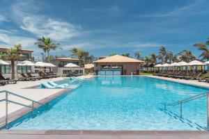 a pool at the resort with chairs and umbrellas at Vila Galé Collection Sunset Cumbuco in Cumbuco