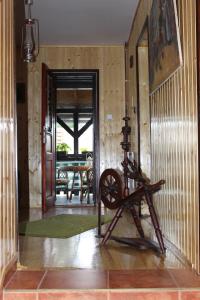 a room with a wooden wall with a spinning wheel at Penzion Pod Rozhlednou in Janov