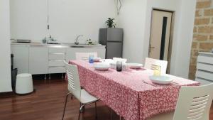a table with white chairs and a pink table cloth at Cosy Open Space Apartment Bari in Bari