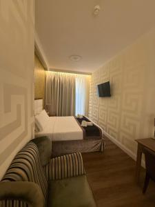 a hotel room with a bed and a couch at Hotel Montreal in Florence