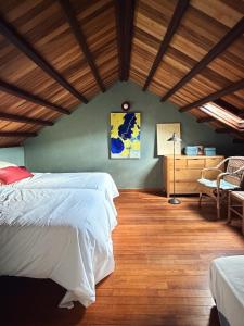 a bedroom with a white bed and a wooden floor at Casa Malde in Cedeira
