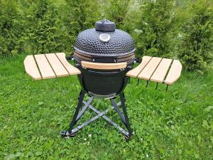 a grill with two picnic tables on the grass at Tuule in Jeedasküla