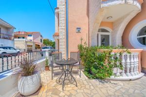 a patio with a table and chairs on a balcony at Garden House Vodice in Vodice