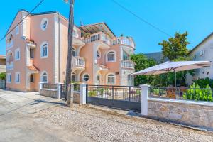 a large pink house with a fence in front of it at Garden House Vodice in Vodice